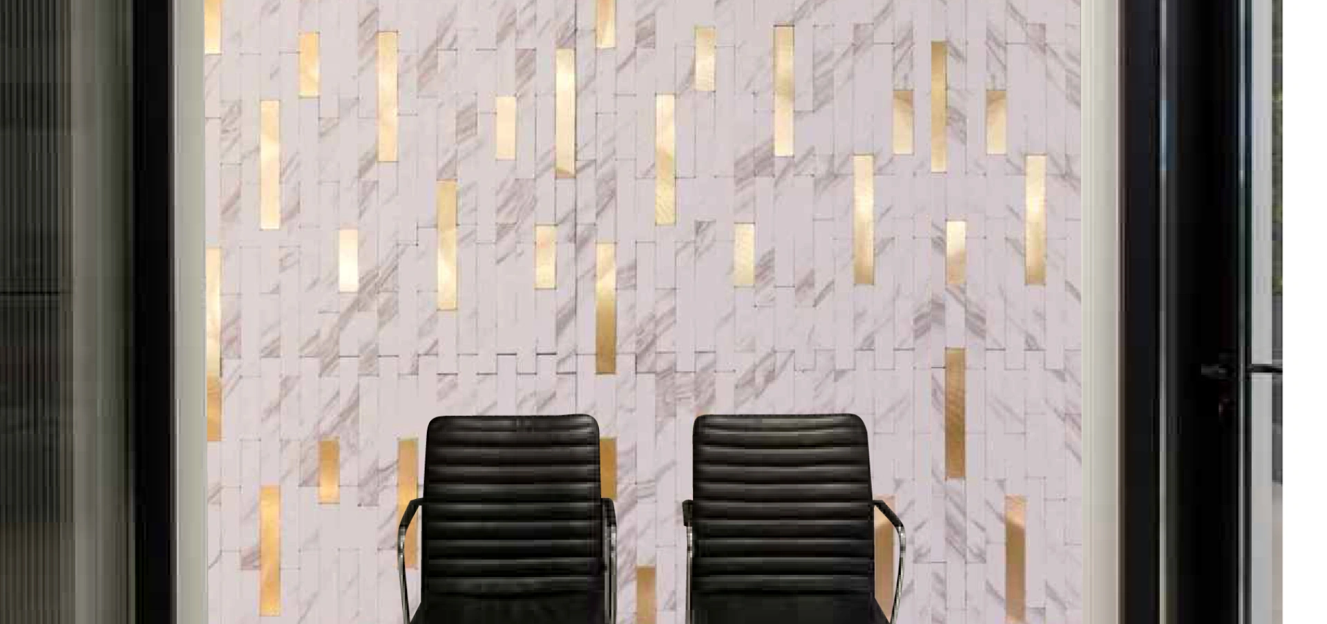 A decorative wall featuring marble mosaic tiles with golden accents, creating a luxurious backdrop behind two black leather chairs.