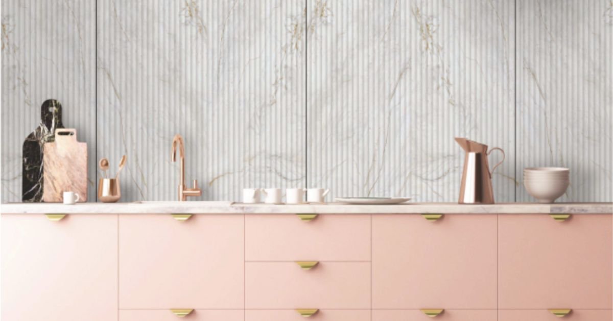 White marble fluted acrylic panel with gold vein accents in a modern kitchen with pink cabinetry.
